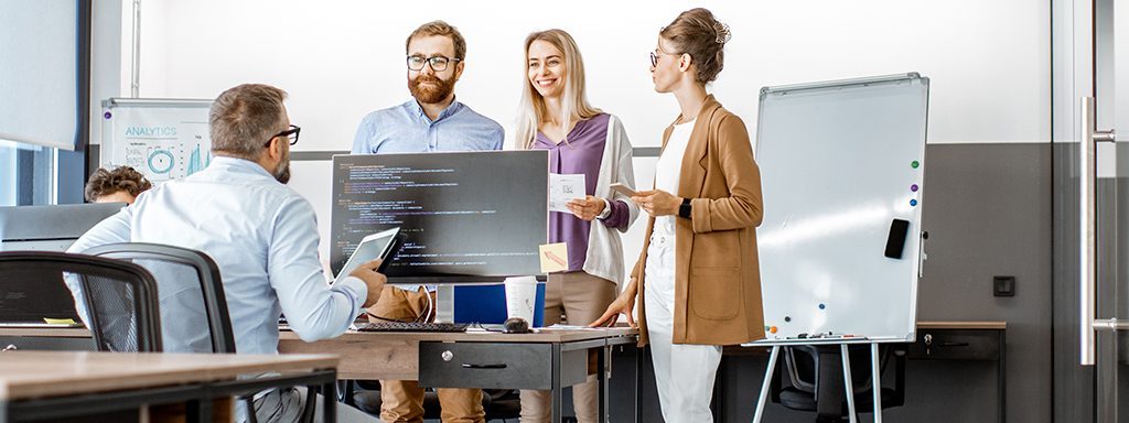 Men and women surrounding a computer