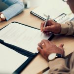 Discussing Public Liability Insurance: Close-up of hands during contract signing