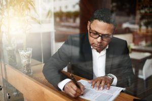 Businessman reviewing Public Liability Insurance papers at cafe table