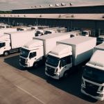 Fleet of insured delivery trucks lined up at a warehouse—ideal for illustrating insurance policies for trucking fleets.